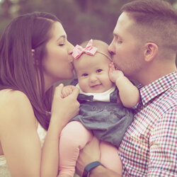 titelbild elterngeld blogbeitrag - 01 familie, vater und mutter halten die kleine tochter in der mitte